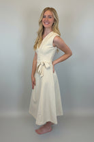 Woman wearing a light-colored dress against a white background